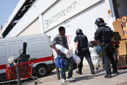 Un inmigrante, con sus objetos personales, tras ser desalojado por los Mossos d'Esquadra de una de las naves en el Poblenou de Barcelona.