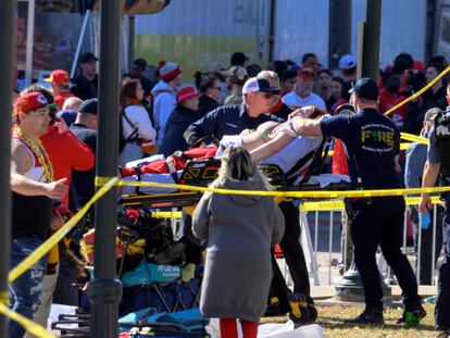 A woman is taken to an ambulance after an incident following the Kansas City Chiefs NFL football Super Bowl celebration in Kansas City, Mo., Wednesday, Feb. 14, 2024.