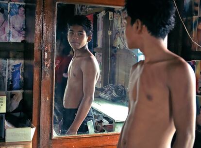 Un niño se mira en un espejo en su casa.