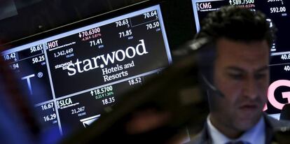 Brokeres con una pantalla con la cotizacion de Starwood.