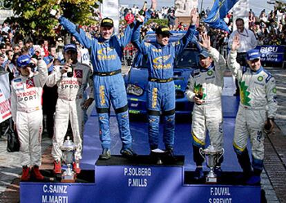 El podio tras la carrera de ayer. A la izquierda, Marc Martí, su copiloto, y Carlos Sainz.