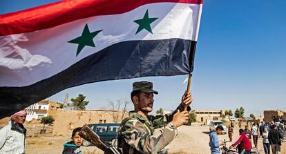 Un soldado del régimen ondea una bandera siria.