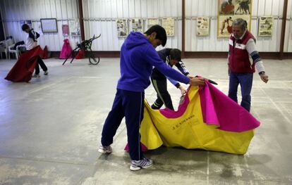 Antes de lanzarse al ruedo los chicos tienen que aprender los movimientos, la técnica del tore. Es lo que se denomina toreo de salón y en la Escuela de tauromaquia de Madrid lo practican en una nave. El suelo, de pavimento, está cubierto de arena que los alumnos traen adherida a sus capotes y muletas.