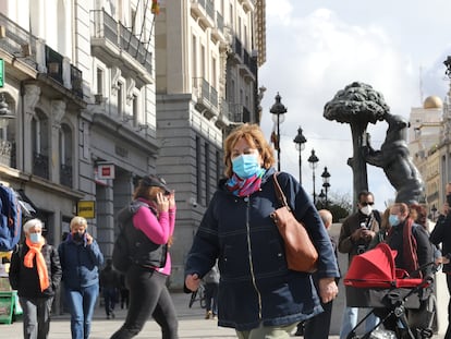 Transeúntes caminan por las inmediaciones de la Puerta del Sol en Madrid, el viernes.