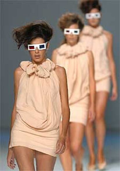 Tres modelos muestran creaciones de la marca Joan Pastor en el desfile colectivo de creadores emergentes.