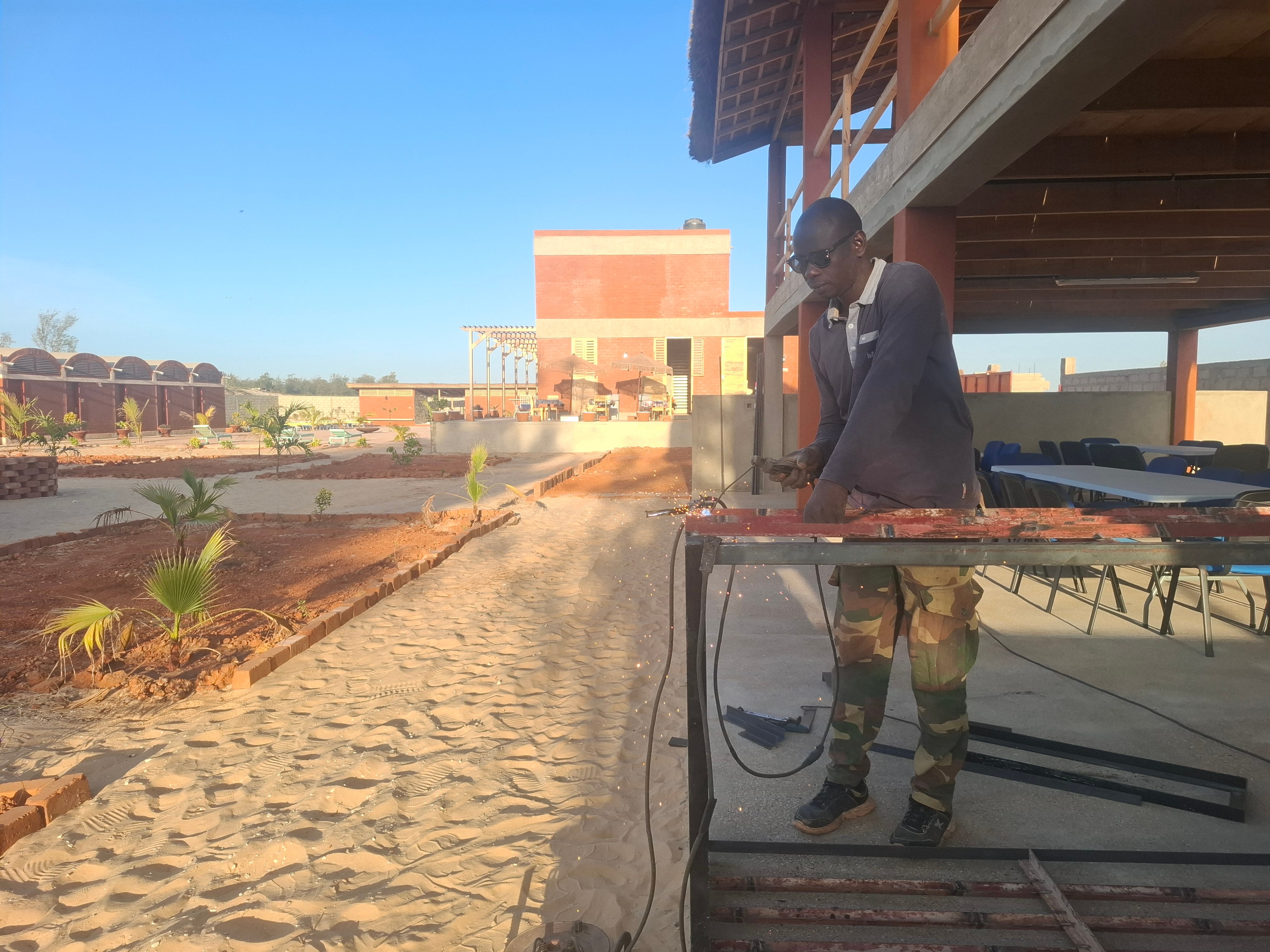Un obrero da los últimos retoques al hotel escuela Baobab (Senegal) antes de su inauguración a principios de marzo de 2026.