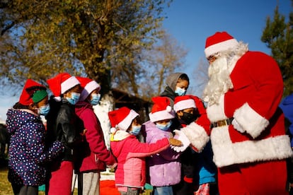 Rodolfo Rentería, un bombero disfrazado de Papá Noel, saluda a los niños que hacen cola para recibir regalos donados en Ciudad Juárez, el viernes.