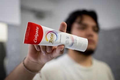 Un joven sostiene la pasta de Colgate Total prevención activa Clean Mint.