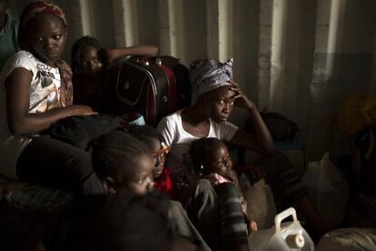 Mujeres y niños de la República Centroafricana, se esconden dentro de un camión contenedor para que el resto de ciudadanos no vean cómo huyen de su país. Esperan para partir hacia el oeste del país, hacia la frontera con Camerún, en un convoy escoltado por miembros de Unión Africana por la paz.