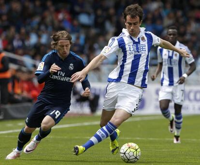 El centrocampista de la Real Sociedad Mikel Oyarzabal (d) lucha un balón con el centrocampista croata del Real Madrid Luka Modric (i).