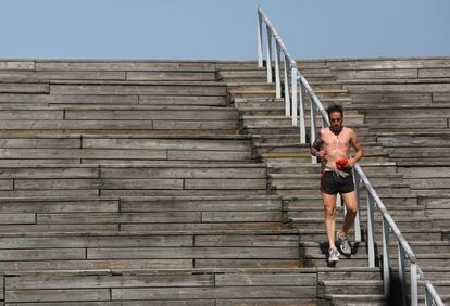 Un hombre hace deporte sin camiseta en el Parque Lineal del Manzanares.