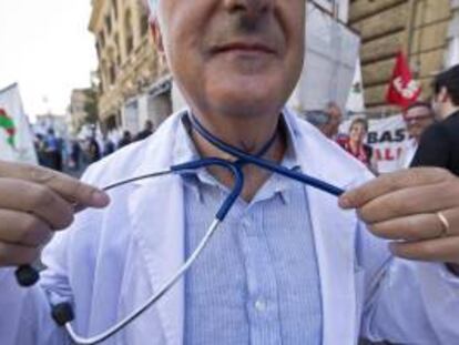 Un trabajador de Sanidad simula ahorcarse con un estetoscopio durante una manifestación a las puertas del Ministerio de Economía en Roma (Italia). EFE/Archivo