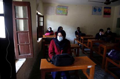 Estudiantes cachemires usan mascarilla en el primer día de clase tras la reapertura de los centros educativos en la Cachemira india, 11 meses después de su cierre a causa de la pandemia, en Srinagar, este lunes.