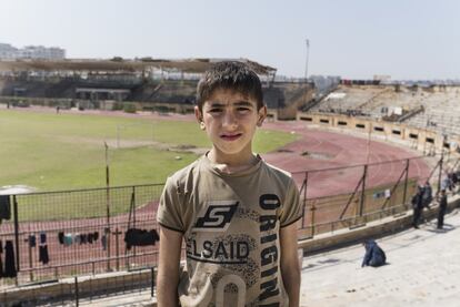 Mustafá, un niño de 9 años que vive junto a su familia en el estadio tras resultar recientemente desplazado por los combates. Las gradas del estadio de Idlib sirven para secar la colada, pero nadie vive en ellas ni en el césped porque, dada su visibilidad, podrían ser objeto de un bombardeo aéreo del régimen.