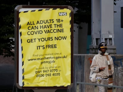 Un hombre pasa junto a un cartel que anima a la población a vacunarse contra la covid, este lunes en Mánchester (Reino Unido).