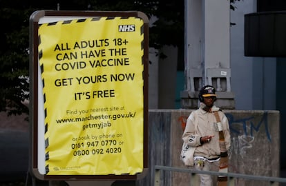 Un hombre pasa junto a un cartel que anima a la población a vacunarse contra la covid, este lunes en Mánchester (Reino Unido).