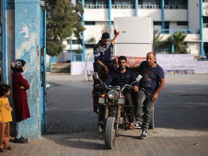 Varios palestinos trasladan este viernes en una moto sus pertenencias tras abandonar la escuela de Naciones Unidas donde estaban refugiados en Gaza.