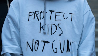 A person wears a sweatshirt that reads 'Protect kids not guns,' during a community vigil near the Tennessee State Capitol Building months after the Covenant School shooting and protests rocked the state capitol in Nashville, Tennessee, January 9, 2024.