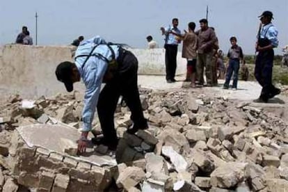 Un policía iraquí inspecciona los restos de una tumba sagrada chií destruida tras la explosión de una bomba en Bagdad.