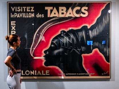 Una joven frente al cartel de la Exposición Colonial de París de 1931, que emplea el icono de la mujer mangbetu, este miércoles en el IVAM.