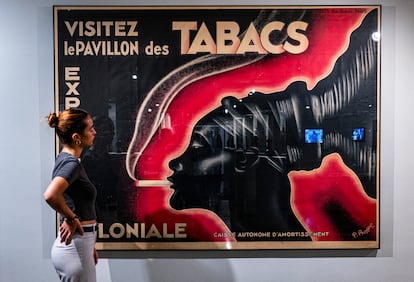 Una joven frente al cartel de la Exposición Colonial de París de 1931, que emplea el icono de la mujer mangbetu, este miércoles en el IVAM.