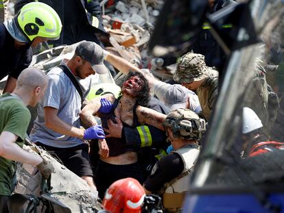 Los equipos de rescate sacan a una víctima de entre los escombros tras el ataque ruso en Kiev este lunes.