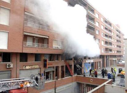 Miembros de los servicios de emergencias conversan frente al restaurante "Exquisit", ubicado en los bajos del inmueble situado en el número 1 de la calle Manuel de Pedrolo de Lérida.
