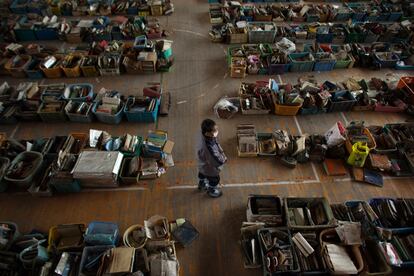 Un hombre camina entre las cajas dispuestas en un gimnasio de Natori, con objetos recuperados entre las ruinas causadas por el terremoto y posterior tsunami de 11 de marzo.