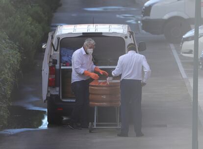 Workers remove a coffin from a senior care home in Valdemoro.