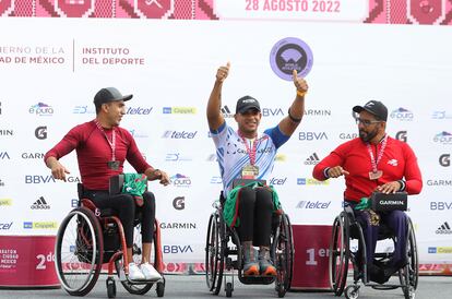 El mexicano Marco Caballero en segundo lugar, el colombiano Francisco San Clemente en primer lugar y el mexicano Fernando Sánchez Nav en tercer lugar, posan en el podio tras finalizar la categoría de silla de ruedas de la XXXIX edición del Maratón de la Ciudad de México.