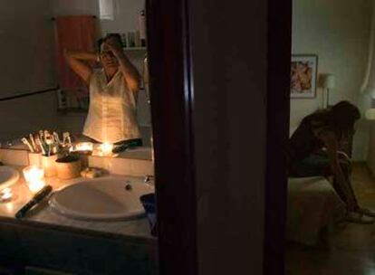 Una vecina de Congres-Indians se peina en el baño de su casa a la luz de varias velas.