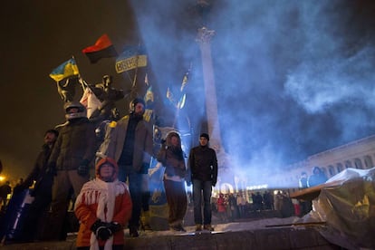 Activistas sindicales pro-europeos sobresalen desde la estatua histórica decorada con banderas de Ucrania.