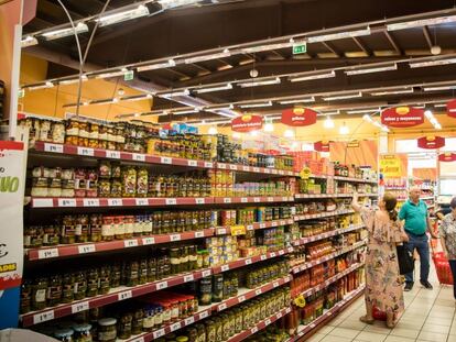 Varios consumidores compran alimentos en un supermercado.  