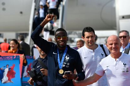 El mediocentro Blaise Matuidi saluda puño en alto y con la medalla de oro del Mundial de Rusia 2018 colgada del cuello a su llegada a París. 