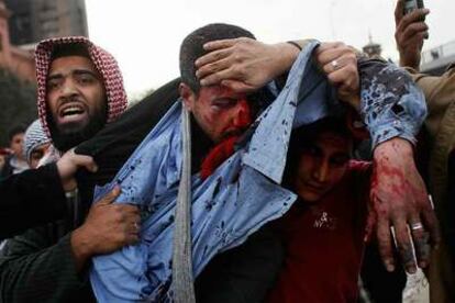 Un manifestante anti-Mubarak herido de una pedrada es trasladado fuera de la plaza de la Liberación.