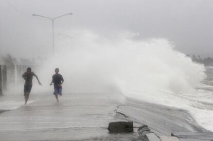 Habitantes de Legazpi escapan de las grandes olas provocadas por el tifón Hagupit. La ciudad, situada al borde del océano Pacífico ha sufrido fuertes destrozos causados por la tormenta.