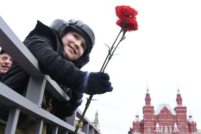 Um menino leva flores antes da celebração pelo 72º aniversário do fim da Segunda Guerra Mundial.