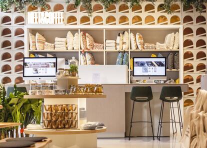 El rincón Meet & Coffee, donde los visitantes a la tienda de Kave Home de Madrid pueden tomar un café mientras navegan por la colección desde un ordenador con gran pantalla. Las celosías de las paredes, de inspiración mediterránea, reproducen el logo de la firma de muebles. |