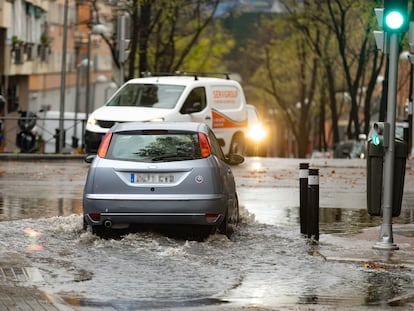 Un coche circula por una balsa de agua en la avenida de la Ciudad de Barcelona, el miércoles 14 de diciembre.