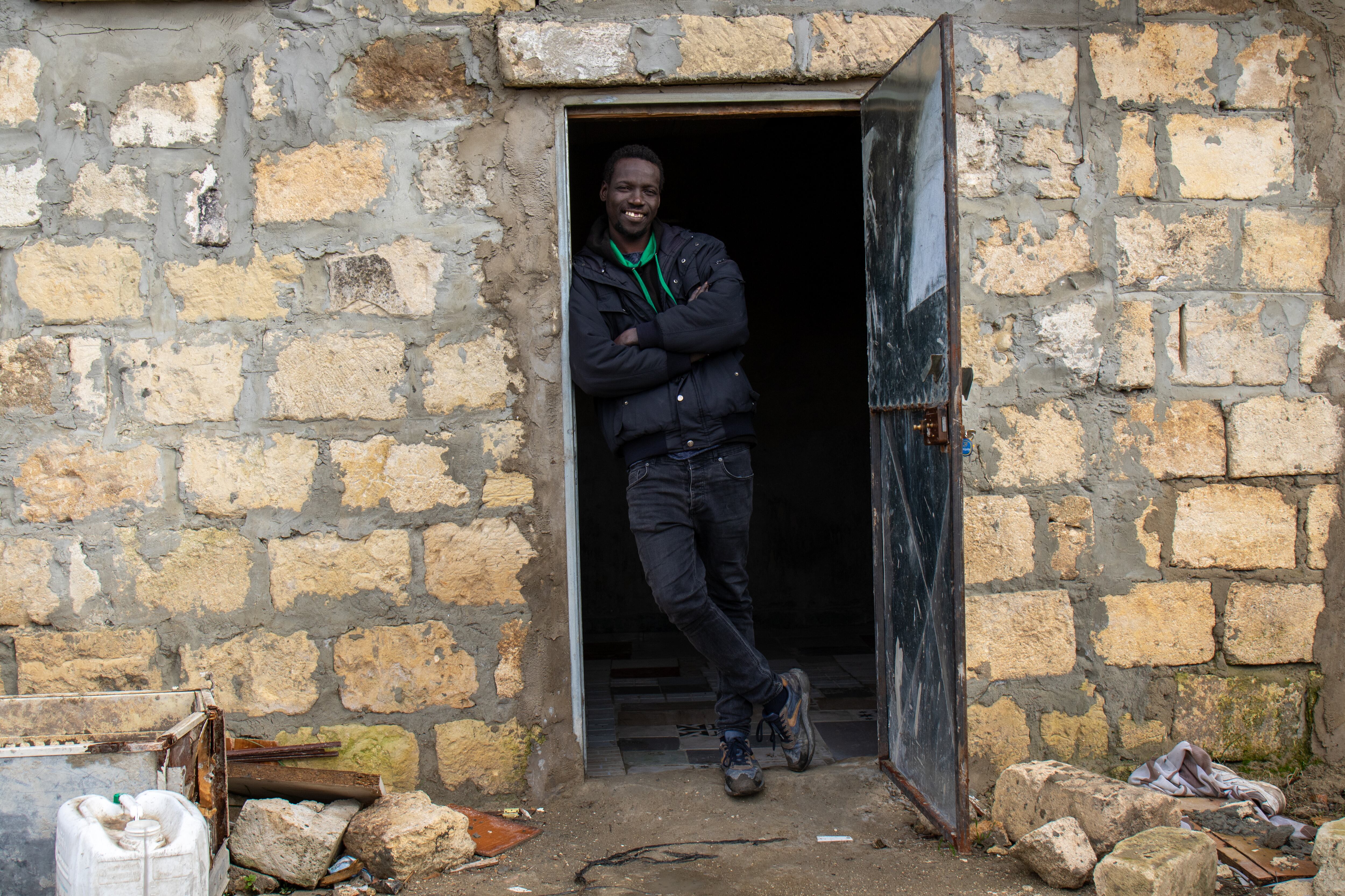Abdul Camara, senegalés, que vive en el poblado de Borgo Mezzanone desde hace siete años, en la puerta de la casa que ha construido con sus propias manos.