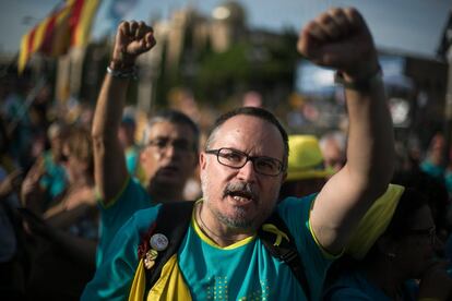 Manifestantes alzan los punos mientras cantan 'Els segadors' durante la manifestación en Barcelona.