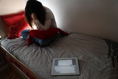 Una adolescente en su habitación con una tablet con el texto: Déjame en paz.