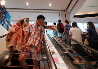 Un grupo de jóvenes disfrazados durante un recorrido por un centro comercial de Bangkok (Tailandia), el 31 de octubre.