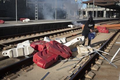 Un trabajador vierte aguarrás en los adoquines de plástico para cortar las vías del tren en la estación de Renfe de Cádiz.