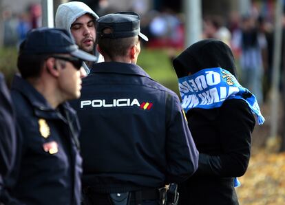 Agentes de la policía identifican a un aficionado del Deportivo de la Coruña en el exterior del estadio Vicente Calderón.