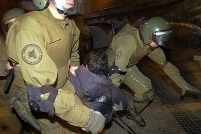 Un manifestante es detenido frente al Estadio Nacional de Santiago.