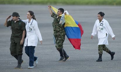 El sargento Luis Alfredo Moreno (segundo a la derecha), agita una bandera colombiana en el aeropuerto colombiano de Villavicencio.