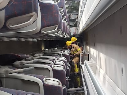 Varios bomberos trabajan en ell interior del autocar, este domingo. 