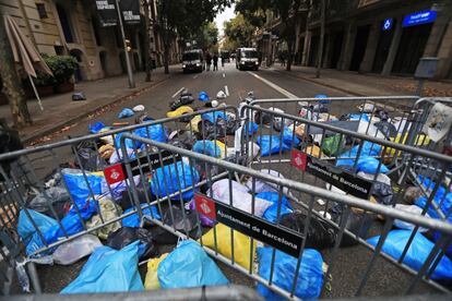 Protesters throw bags of trash in front of the security cordon outside the central government’s delegation headquarters in Barcelona on Sunday.