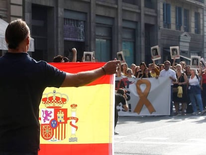 Un hombre con una bandera de España se encara con los centenares de personas que cortan la céntrica Via Laietana de Barcelona.